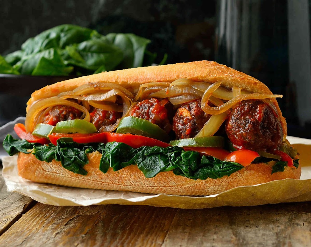 Sandwich de albondigas con pimientos y cebolla en pan crujiente